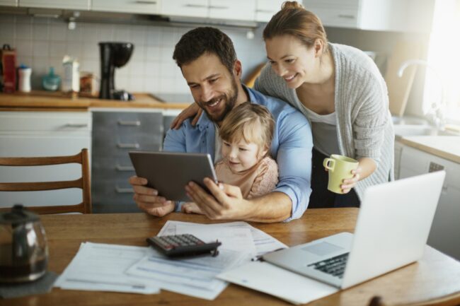 Family in the Kitchen looking at Financial Plan on iPad modified Family Reviewing Financial Plan Portfolio