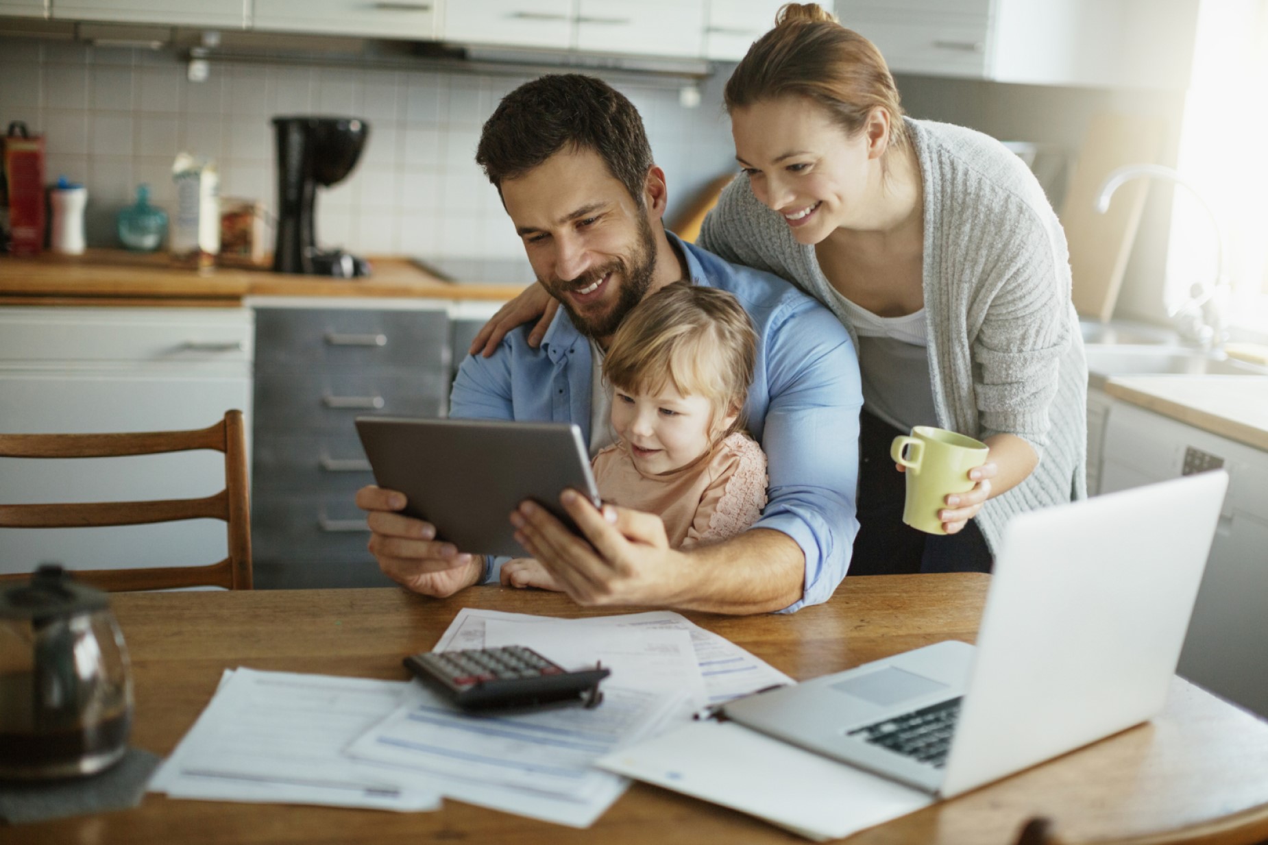 Family in the Kitchen looking at Financial Plan on iPad modified Family Reviewing Financial Plan Portfolio